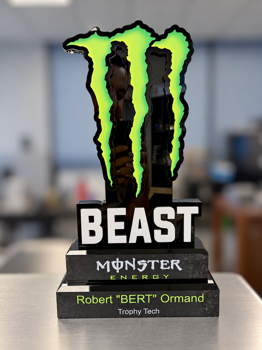 Custom layered acrylic BEAST award with a routed green claw graphic on a stepped black base