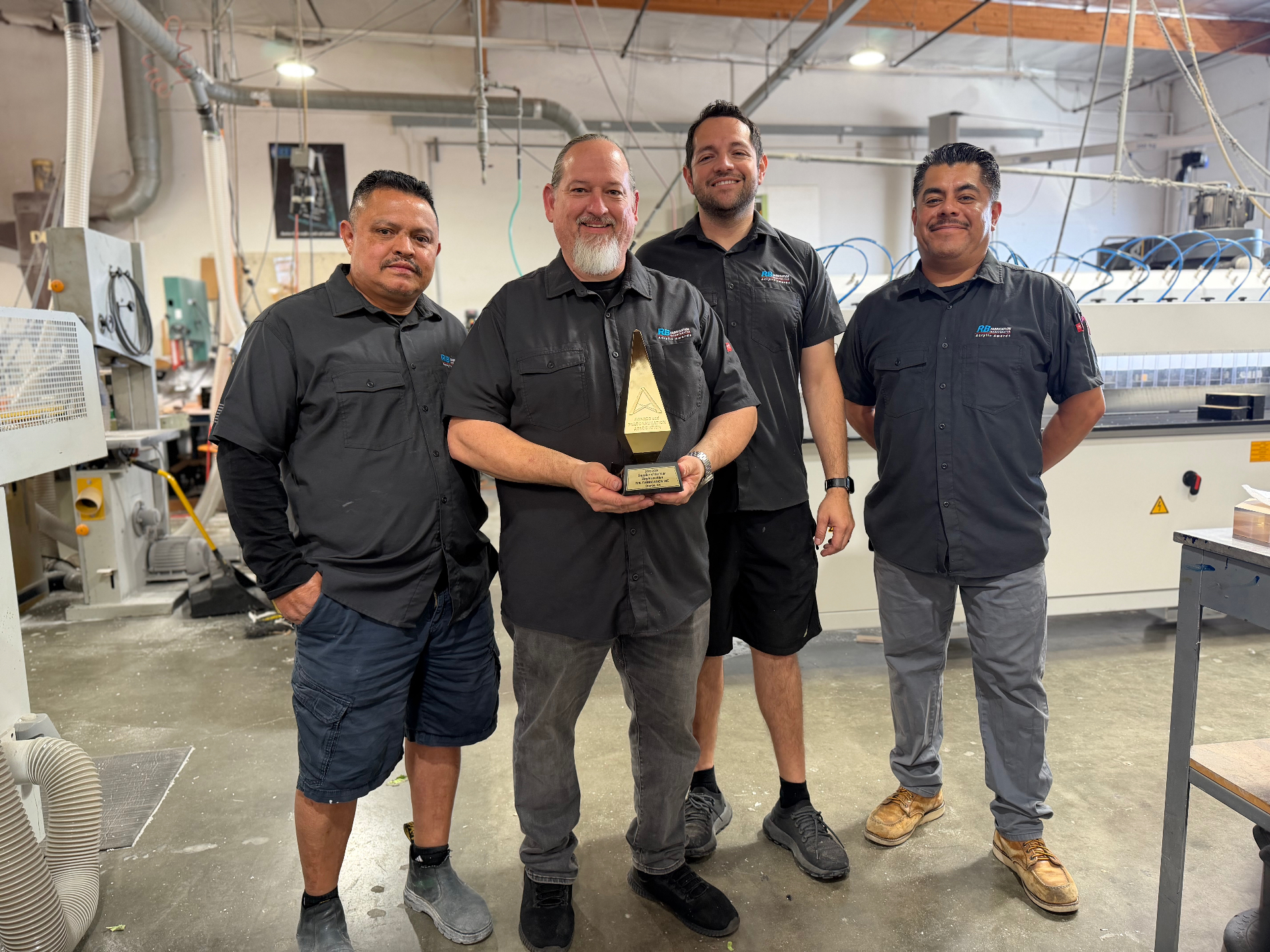 The R.B. Fabrication team on the shop floor in Orange, California holding an industry award
